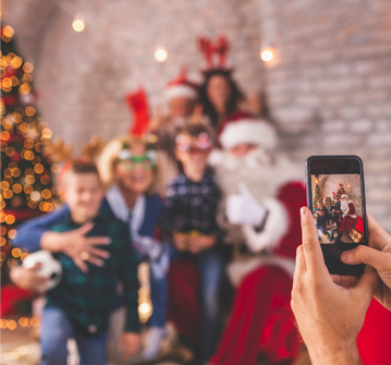 Family taking a holiday photo on a smartphone, illustrating the importance of preserving digital memories through digital legacy planning.